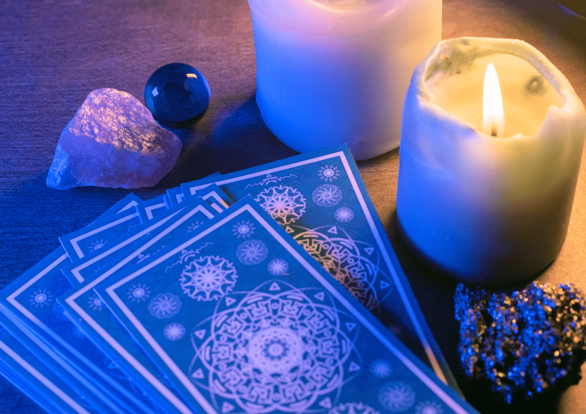 Carta del tarot que se encuentra en la mesa donde al lado hay dos velas encendidas para hacer un ambiente más espiritual