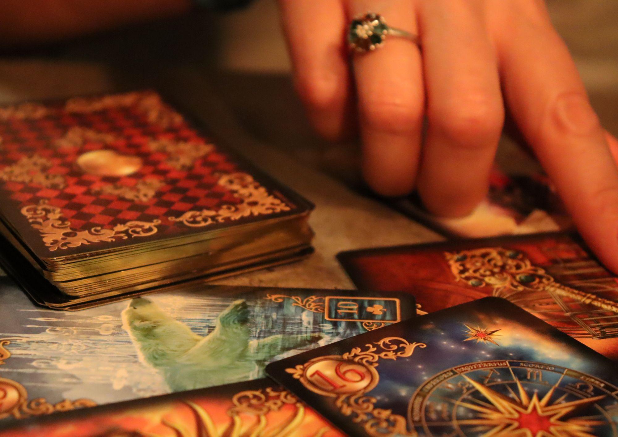 Persona experta con una baraja de cartas del tarot en la mesa